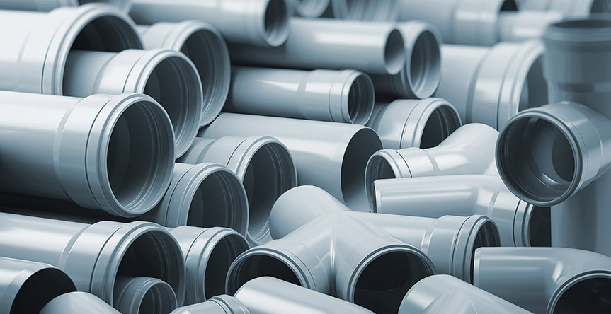 PVC plastic pipes and tubes stacked in warehouse.