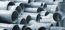 PVC plastic pipes and tubes stacked in warehouse.